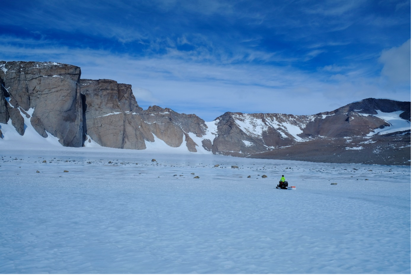 Heading towards the 800m high cliffs across a blue ice field at Troll Station, Antarctica during the BIOICE Project. The translucent blue ice enables sub-surface melting near dark debris particles to sustain microbial ecosystems.