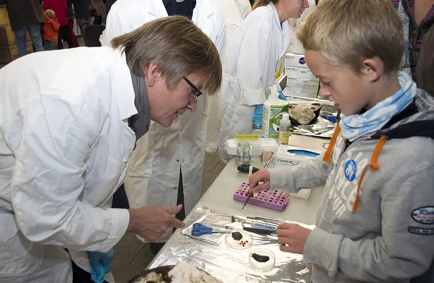 Forskningstorget 2011 Geir Wing Gabrielsen helps young boy in looking at samples from a bird